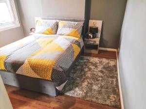 伦敦The Navarone Blue Orchid Flat的一间卧室配有一张带毯子和地毯的床