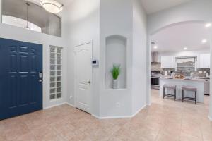 嘉年165th Goodyear home的走廊上设有蓝色门和厨房