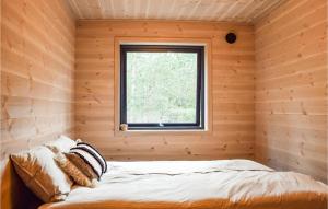 里瑟尔Lovely Home In Risr With Kitchen的木制客房的一间卧室配有一张床,设有窗户