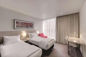 墨尔本墨尔本港区旅程住宿酒店的酒店客房配有两张床和一张书桌