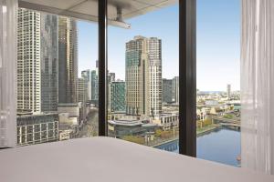 墨尔本Vibe Hotel Melbourne的享有城市天际线景致的卧室
