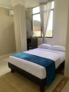 曼塔Reef Hostel Manta的一间卧室设有一张大床和窗户