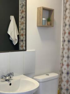 卡尔德拉Caldera Apartment的浴室配有白色卫生间和盥洗盆。