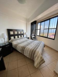 塔斯科·德·阿拉尔孔Casa Vista hermosa de taxco的一间卧室设有一张床和一个大窗户