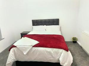 伯明翰Lovely 3 Bed Apartment Near QE Hospital Harborne Birmingham New的一间卧室配有一张带红色毯子的大床