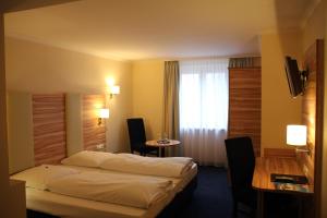 慕尼黑丹尼尔酒店的酒店客房配有一张床铺和一张桌子。