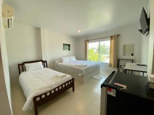 华富里Baan Ruay Suk Resort, Lopburi的酒店客房配有两张床、一张书桌和一张书桌。