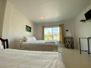 华富里Baan Ruay Suk Resort, Lopburi的酒店客房设有两张床和窗户。