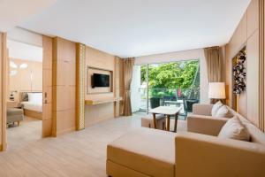 芭东海滩Clarian Hotel Beach Patong的带沙发、床和电视的客厅