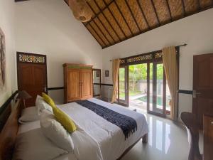 海神庙Agung Village的一间卧室设有一张大床和一个大窗户