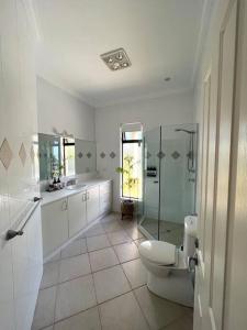 林肯港Zentala的一间带卫生间和玻璃淋浴间的浴室