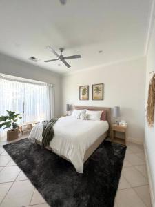 林肯港Zentala的白色卧室配有床和吊扇
