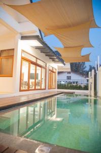 哈德超珊兰Chao Sam Ran Pool Villa Phetchaburi หาดเจ้าสำราญ เพชรบุรี ราคาสำหรับ 8 ท่าน的一座带天花板的房屋内的游泳池
