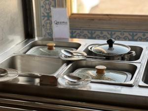 卡拉尔哥特Hotel Hayatt Sukkur的厨房配有3个锅碗瓢盆和炉灶