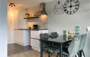 布勒伊尼瑟Amazing Apartment In Bruinisse With Wifi的厨房配有桌椅和墙上的时钟