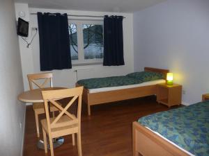 汉堡汉赛胡斯酒店的客房设有两张床、一张桌子和一扇窗户。