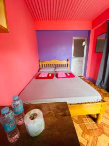 巴纳韦Batad Hillside Inn and Restaurant的红色和紫色墙壁间的一张床
