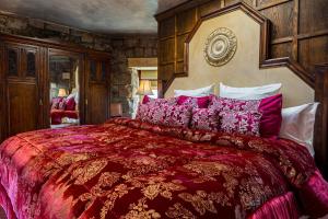 爱丁堡Craigiehall Temple的一间卧室配有一张大床、红色毯子和枕头