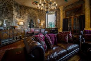 爱丁堡Craigiehall Temple的客厅配有棕色皮沙发和吊灯