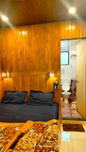 马泰兰altafs motel的一间卧室设有木墙、一张床和卫生间