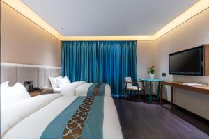 北京唐府中式文化酒店-南锣鼓巷店的酒店客房设有一张大床和一张书桌。