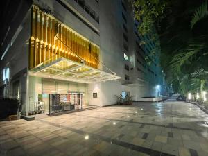 班加罗尔Oakwood Residence Whitefield Bangalore的夜间在建筑物前的一条空的街道