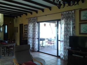 贝赫尔-德拉弗龙特拉El Matorral Chalet的客厅设有滑动玻璃门,可通往庭院
