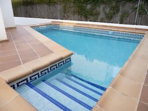 利乌玛Villa Joan的一个带蓝色海水和棕褐色座椅的游泳池