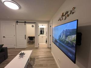 卡尔加里Cozy New Suite in NW Calgary的客厅配有壁挂式大屏幕平面电视