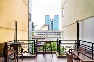 胡志明市Grandma Lu Saigon Hostel - Japan Town的设有带桌椅的市景阳台。