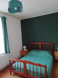 FraizeAppartement à 5 min à pied du centre ville et des sentiers, 6 personnes et 2 SDB的一间卧室配有一张带绿色墙壁的床