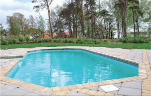 GlemmingeCozy Home In Nybrostrand With Sauna的庭院里的一个蓝色海水游泳池