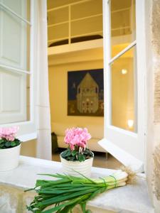 莱切卡萨迪洛套房住宿加早餐旅馆的窗 ⁇ 上两只白色花瓶,花粉红色