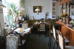 Burgstaedt诺曼斯餐厅及酒店的一间带桌椅的餐厅和一间酒吧