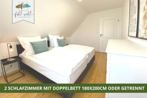 EckersdorfLandhaus Fantaisie - Wohnen nahe Schlosspark -Stadtgrenze Bayreuth für 1-5 Personen的一间卧室配有带白色床单和蓝色枕头的床。