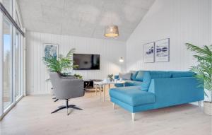 JægersprisAmazing Home In Jgerspris With Indoor Swimming Pool的客厅配有蓝色的沙发和桌子