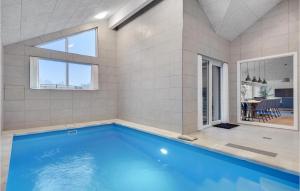 JægersprisAmazing Home In Jgerspris With Indoor Swimming Pool的一座带大窗户的房屋内的游泳池