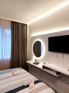 比哈奇Swiss Plus Hotel的酒店客房设有两张床和一台平面电视。