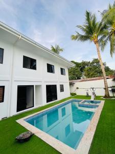 公主港Kasamigos Guesthouse with Fast Internet的棕榈树屋前的游泳池