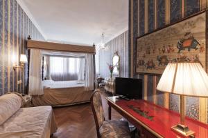 威尼斯帕拉索香东皮亚诺安蒂科酒店的客厅配有床和带台灯的桌子