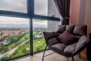 八打灵再也Lumi Tropicana Petaling Jaya by Idealhub的配有大窗户的客房内的椅子
