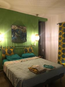 GuéréoChambres vue imprenable的一间卧室配有一张带绿色墙壁的床