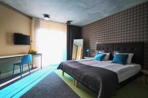 尤尔马拉库尔什Spa中心及酒店的一间卧室配有一张带蓝色枕头的大床