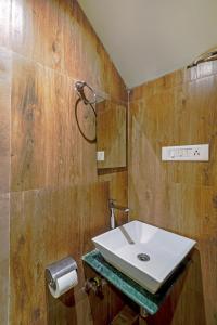 孟买HOTEL SIGNATURE INN的一间带白色水槽和木墙的浴室
