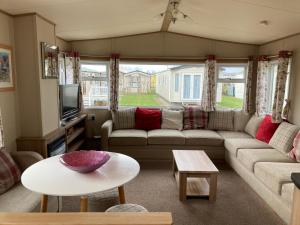 KentBirchington vale caravan holiday park的客厅配有沙发和桌子