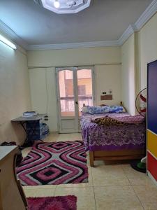 شقة مميزة في وسط بورسعيد的卧室配有一张床,地板上铺有地毯