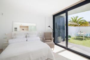 滨海帕尔姆Luxury Avilla Las Olas的白色卧室设有一张大床和一个阳台
