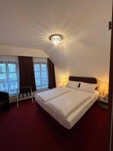 不来梅港Hotel Columbus und Glamping的卧室配有一张白色大床和两个窗户