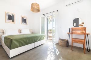 安提帕罗斯岛Statheros Garden的白色卧室设有绿色的床和滑动玻璃门