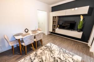 札勒乌New Home Studio的客厅配有桌椅和电视。